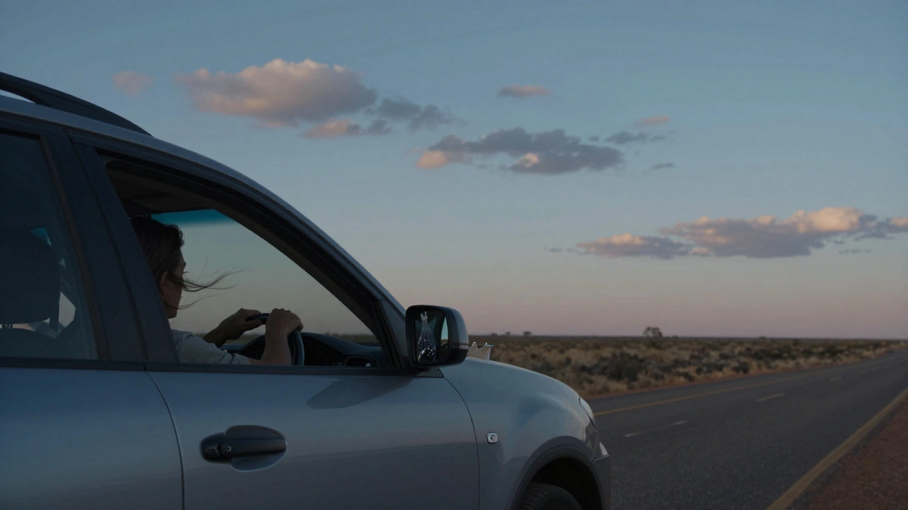 Driver gazing out the window at dusk, no devices, lavender sachet in glovebox, quiet road ahead.